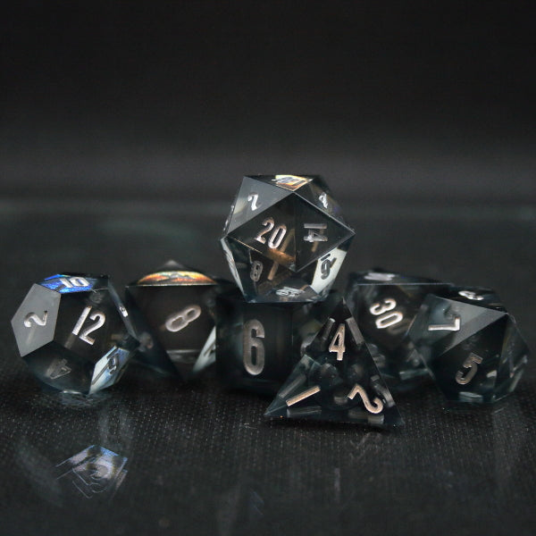 7 piece set of Clear sphere core Dice with a dark-tinted shell. Inked in Silver.