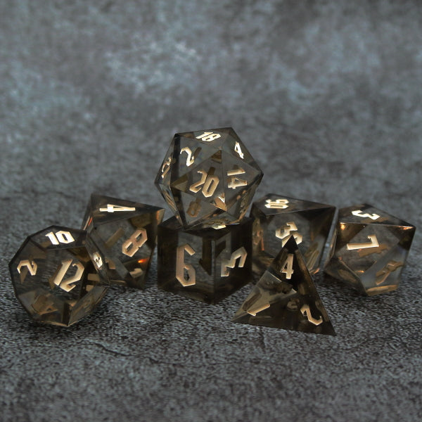 Clear insert 7 piece borderlands style dice set with a dark shell. Inked in an off-white.